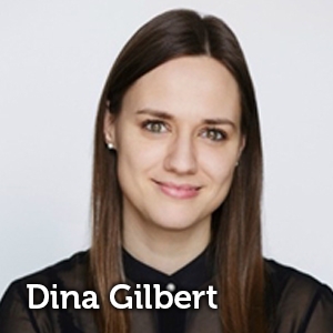 Dina Gilbert smiling at the camera in a black blouse